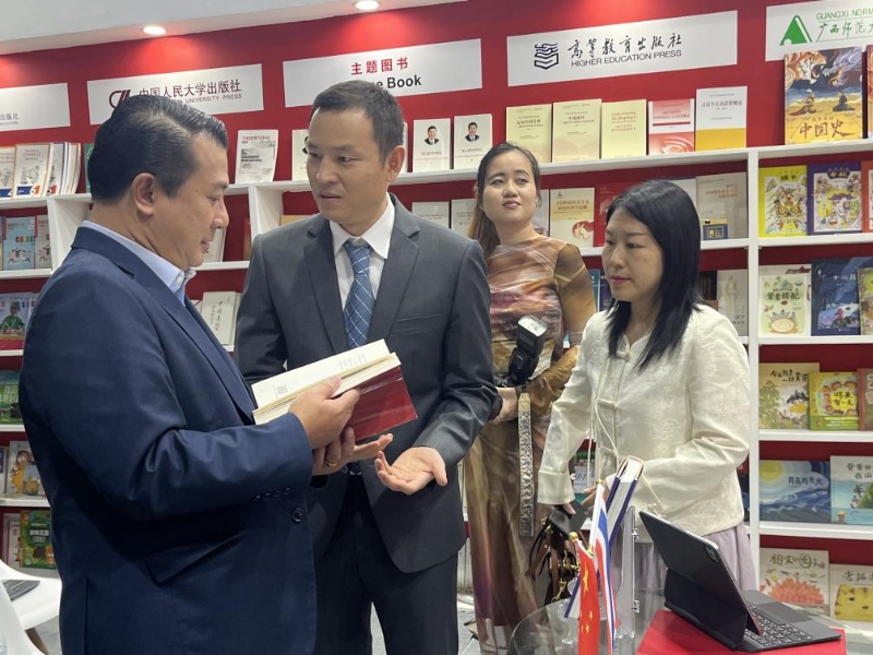 泰國書(shū)商和出版商協(xié)會(huì )主席蘇維奇（左一）在翻閱《近鏡頭：溫暖的瞬間》。（盧雯 攝）jpg_副本.jpg