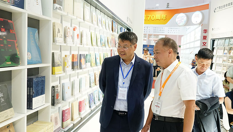 集團公司黨委書(shū)記、董事長(cháng)張藝兵向校黨委副書(shū)記趙鐵詳細介紹出版社圖書(shū)（陳子鋒攝）.JPG